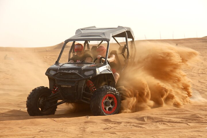 Experience the excitement of navigating Dubai's stunning dunes in a 4x4 dune buggy. Capture breathtaking moments as the sun rises painting the desert landscape in golden hues.